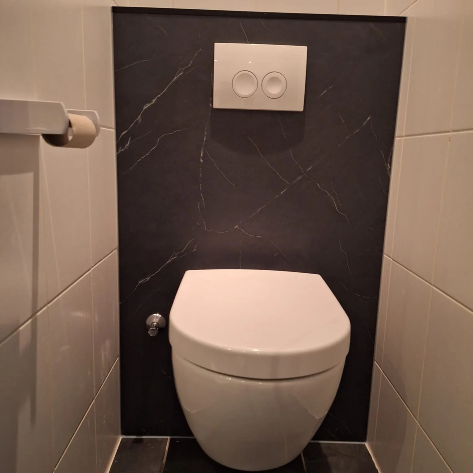 Hangtoilet tegen een voorzetwand met zwart marmerlook paneel