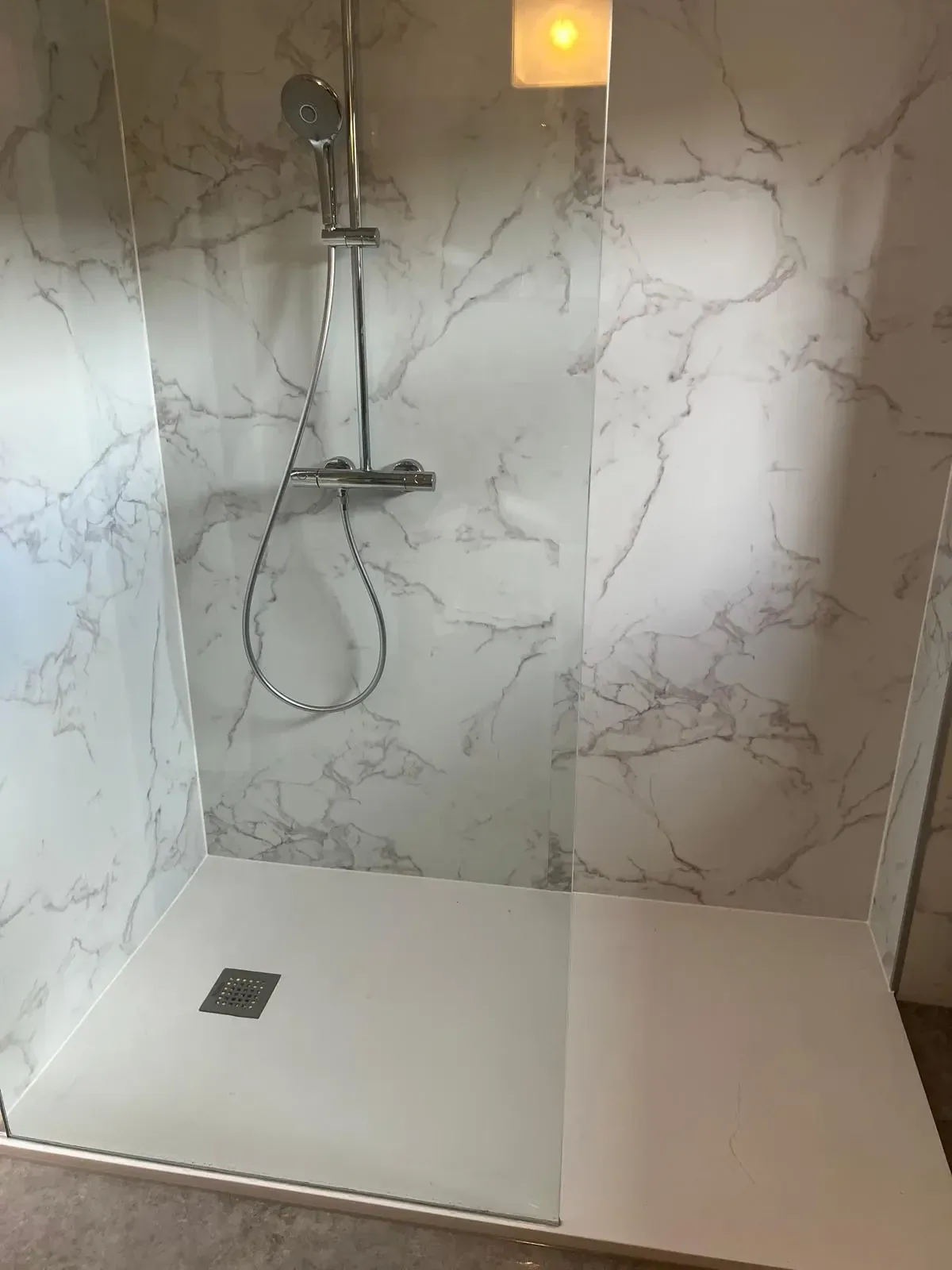 Inloopdouche met witte marmerlook wandpanelen, thermostatische douche en glazen wand