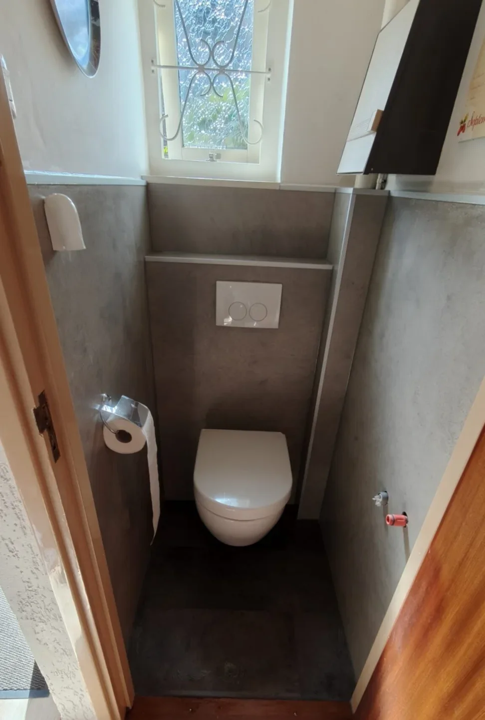 Na: hangtoilet tegen een voorzetwand met grijze wandpanelen